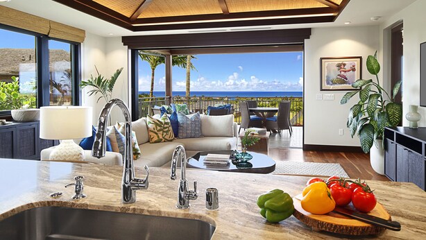 A modern kitchen with a large island, a dining area with a view, and a living room with a sofa and a coffee table.