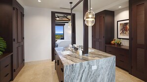 A modern bathroom with a marble sink, wooden cabinets, and a large mirror.
