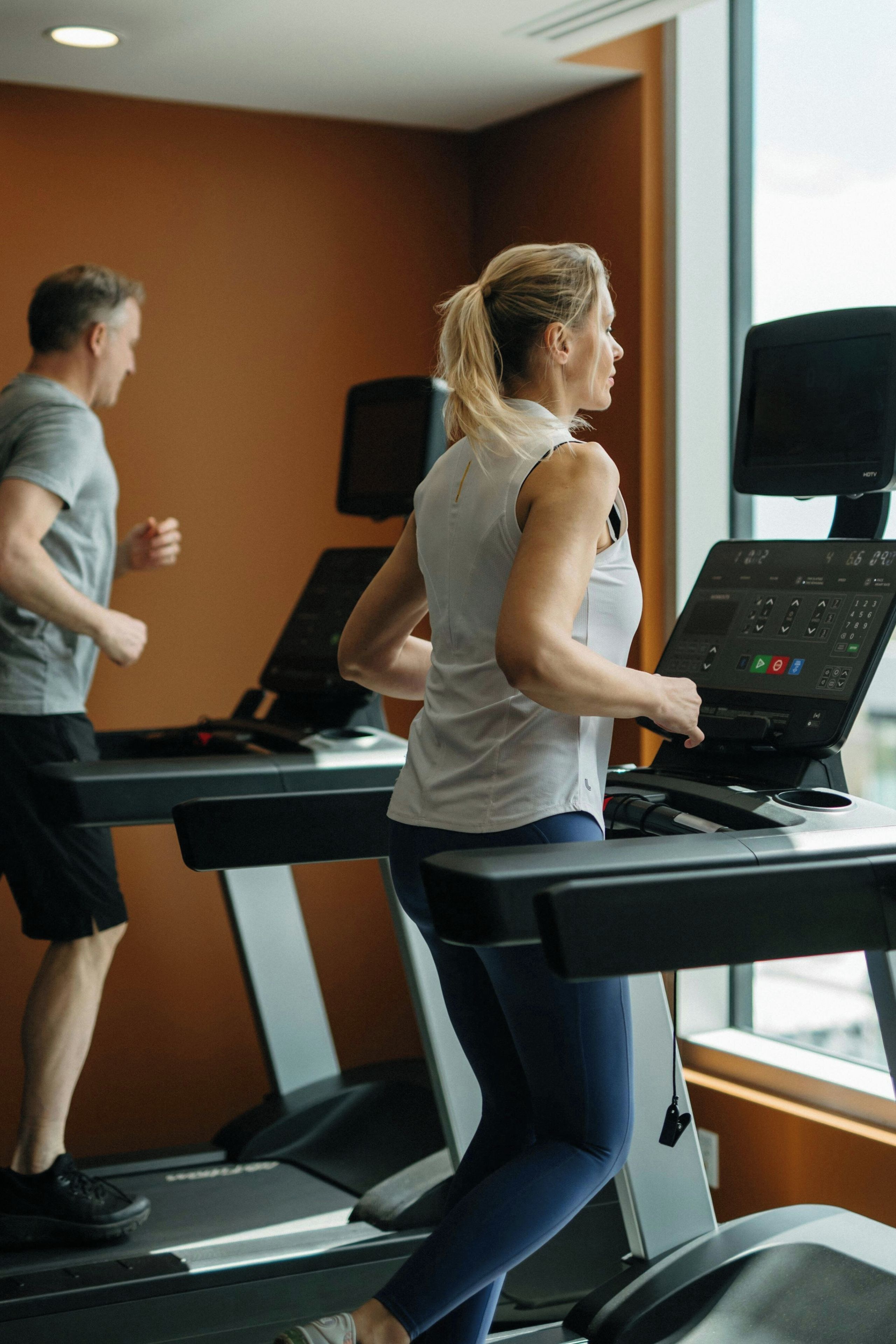 A gym with treadmills and a large window.