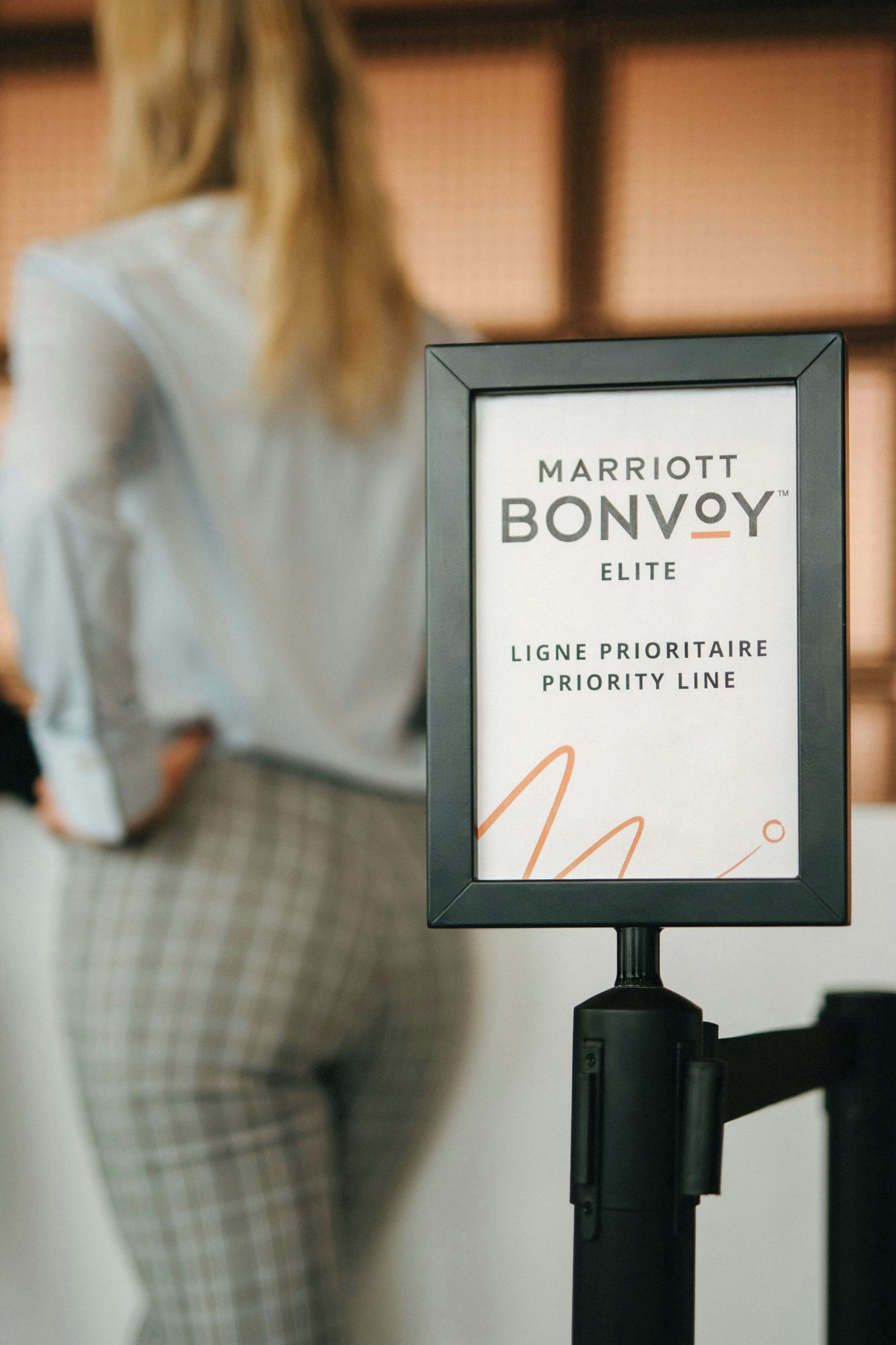 Une plaque encadrée portant l’inscription « MARRIOTT BONVOY ELITE, LIGNE PRIORITAIRE » et placée sur un présentoir.