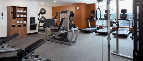 A gym with various exercise equipment, a treadmill, and a weight machine.
