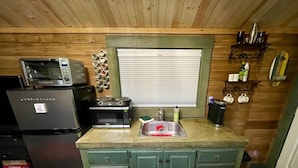 A compact kitchen with a microwave, toaster, and sink.