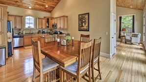 A spacious kitchen with wooden cabinets and a dining area with a wooden table and chairs. - Lakefront Cottage with Private Dock on Norris Lake (Sharps Chapel)