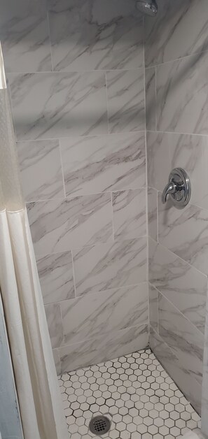 Habitación Deluxe | Baño | Regadera, toallas, jabón, shampoo