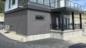 Un bâtiment moderne à deux étages, doté de grandes fenêtres, d’un balcon et d’un toit plat.