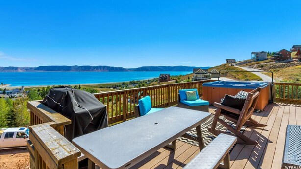 A deck with outdoor furniture, a hot tub, and a view of the ocean. - Raspberry Patch View- New Listing with new hot tub (Garden City)