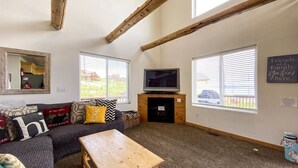 A cozy living room with a sofa, a coffee table, a TV, and a fireplace. - Raspberry Patch View- New Listing with new hot tub (Garden City)