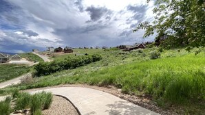 A residential area with houses on a hillside, a curved driveway, and a body of water in the background. - Raspberry Patch View- New Listing with new hot tub (Garden City)