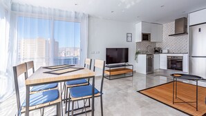 Eine moderne Wohnung mit Essbereich, Küche und großem Fenster mit Blick auf die Stadt.