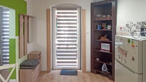Een kleine keuken met een koelkast, een magnetron en een plank met keukengerei.