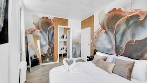 A modern hotel room with a large bed, a wardrobe, and a mirror. - Luxury Living in the Heart of NY (Yonkers)