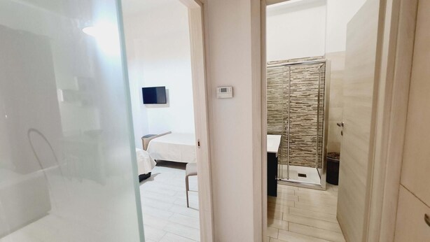 A modern bathroom with a shower, a toilet, and a sink.