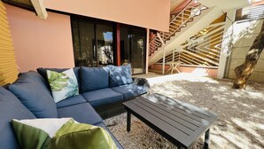 A modern outdoor seating area with a sofa and a table, a staircase, and a tree. - 5 Minute walk to the beach! (Guanacaste Province)