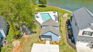 A residential property with a swimming pool, a garage, and a house with a blue roof. - Bright airy lakeside home in gated community (Winchester)