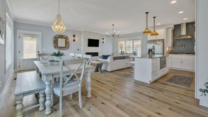 A spacious living area with a dining table, sofa, and kitchen area. - Bright airy lakeside home in gated community (Winchester)