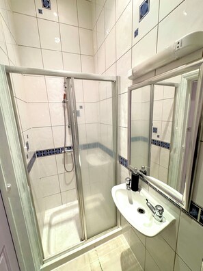 Chuveiro, secador de cabelo, sabonete, shampoo