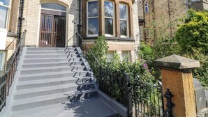 Un edificio de varios pisos con una escalera que conduce a una puerta con el letrero "LISVALE".