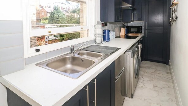 Una cocina compacta con un lavaplatos doble, un microondas y un lavavajillas.