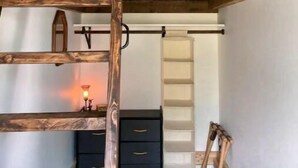 A bunk bed with a wooden ladder, a desk with drawers, a chair, and a small table with a lamp. - Private farm house lock off on sheep farm with salt hot tub (Driggs)