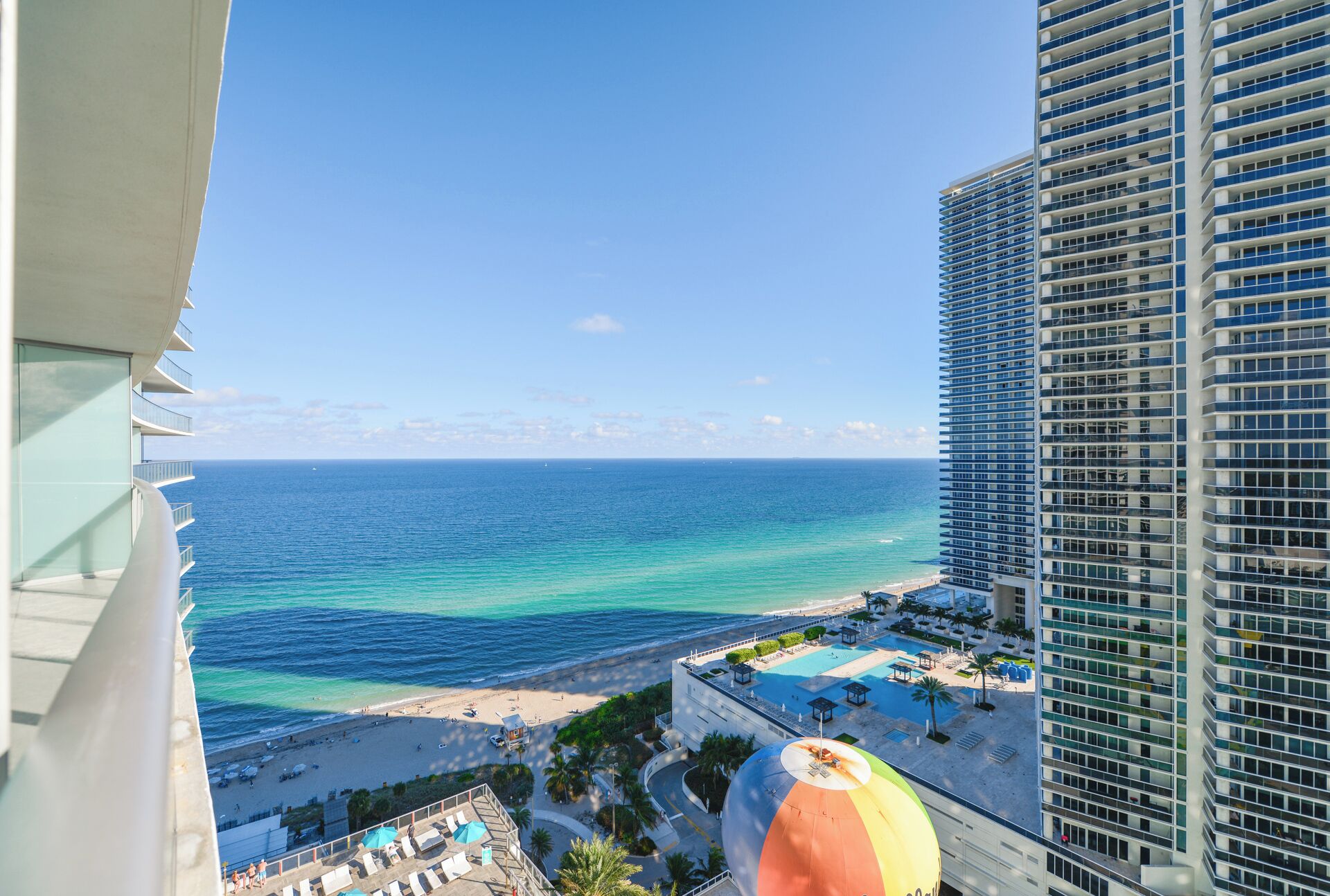 A high-rise hotel with a view of the ocean and beach.