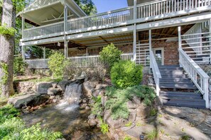 Un bâtiment à deux étages doté d’une terrasse en bois et d’une cascade.