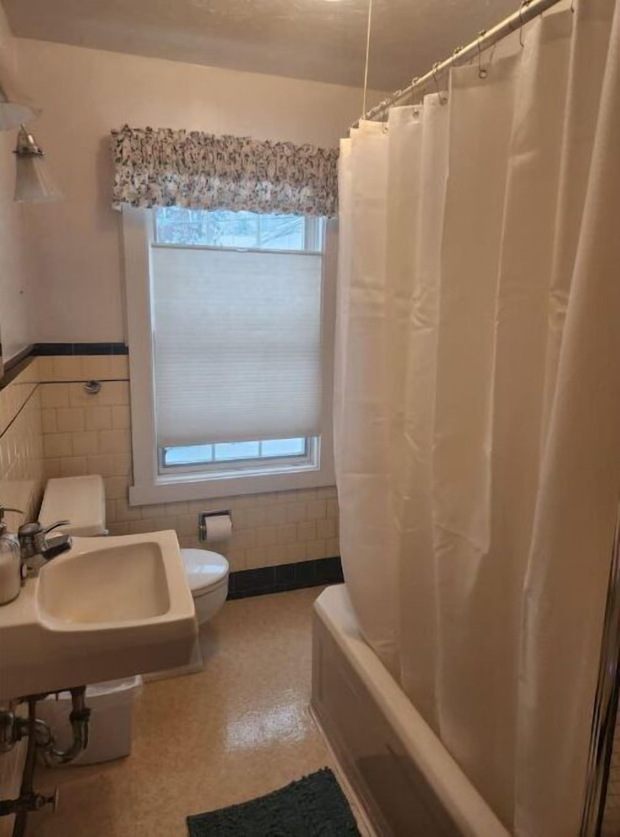 A bathroom with a sink, toilet, and bathtub.