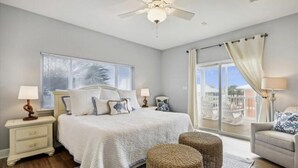 Una camera da letto con un letto grande, due comodini, una ventola a soffitto e vista sull'esterno.