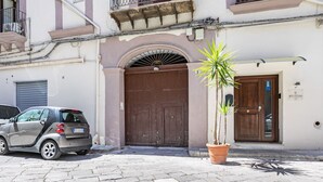 Ein Gebäude mit einer großen Holztür, einem kleinen Auto davor und einem Blumentopf neben dem Eingang.