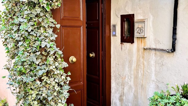 A brown door with a keyhole, a number plate, and a wall-mounted light fixture. - GuestHost - Flaminio MM Comfy Loft - Piazza del Popolo (Roma)
