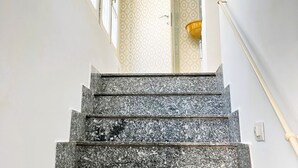 A marble staircase with a handrail, leading to a patterned wall and a light fixture. - GuestHost - Flaminio MM Comfy Loft - Piazza del Popolo (Roma)