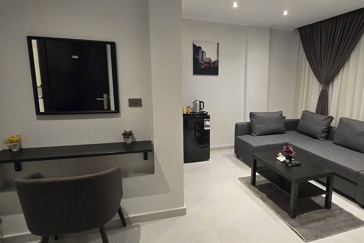 Una sala de estar moderna con un sofá, una mesa de centro y un televisor montado en la pared.