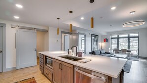 A modern kitchen with a central island, stainless steel appliances, and pendant lighting. - Modern Winter Park Condo w/ Community Hot Tub! (Winter Park)
