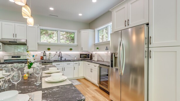 A modern kitchen with white cabinets, stainless steel appliances, and a marble countertop. - Riverfront Hayesville Retreat: Fishing & Kayaking! (Hayesville)