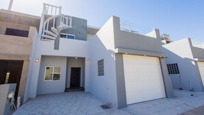 A modern two-story house with a spiral staircase, a garage, and a paved driveway. - Residence 4 (4 Bed 3.5 Bath By FMI Rentals) (Puerto Peñasco)