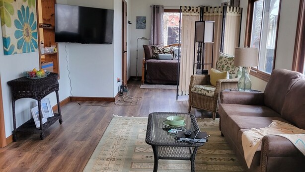 A living room with a sofa, a coffee table, a TV, and a patterned rug. - Cottage at Lake Cumberland; 6m walk to water at Clearwater public boat ramp (Nancy)