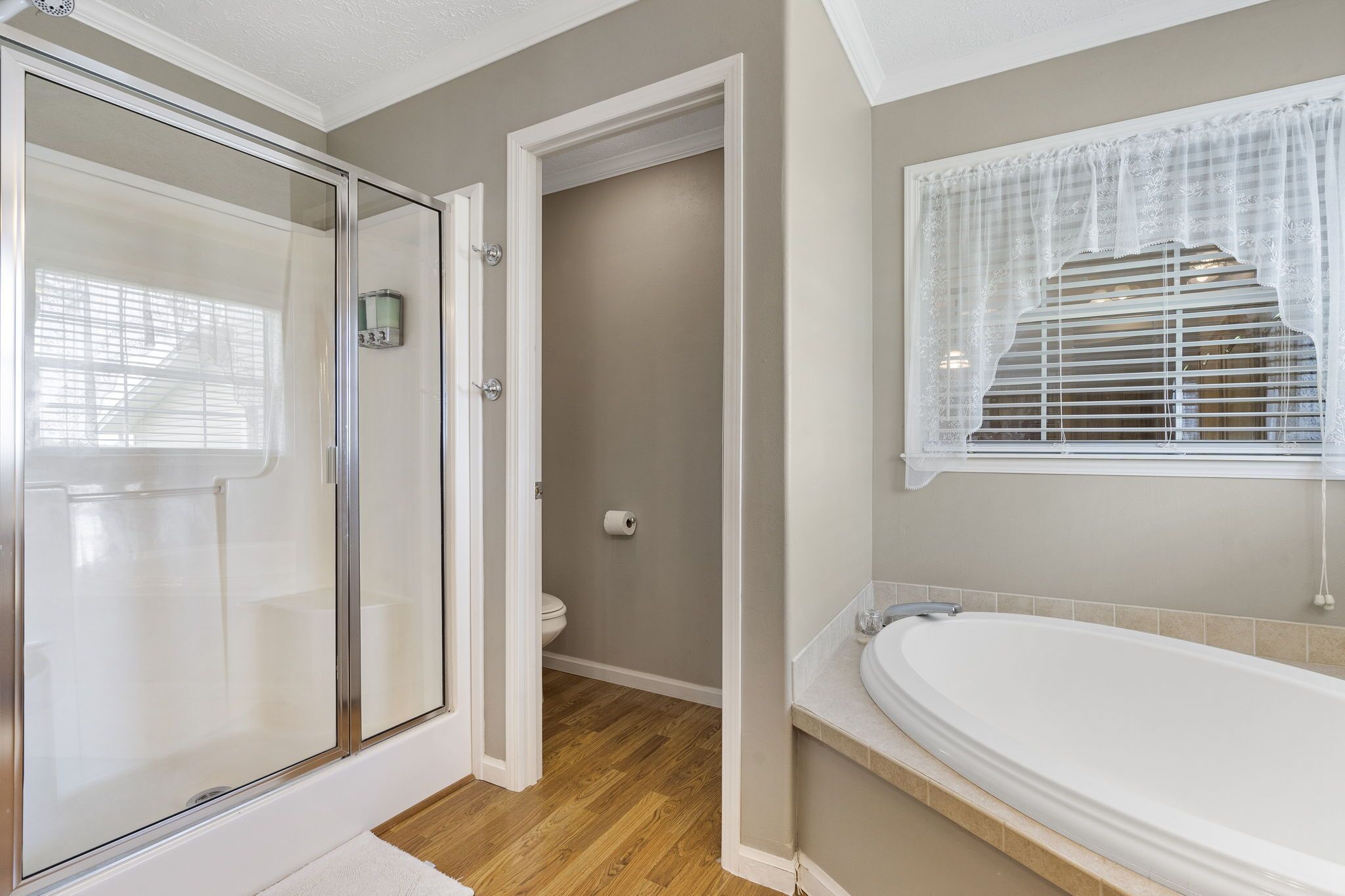 Un baño con cabina de ducha de vidrio, inodoro y bañera.
