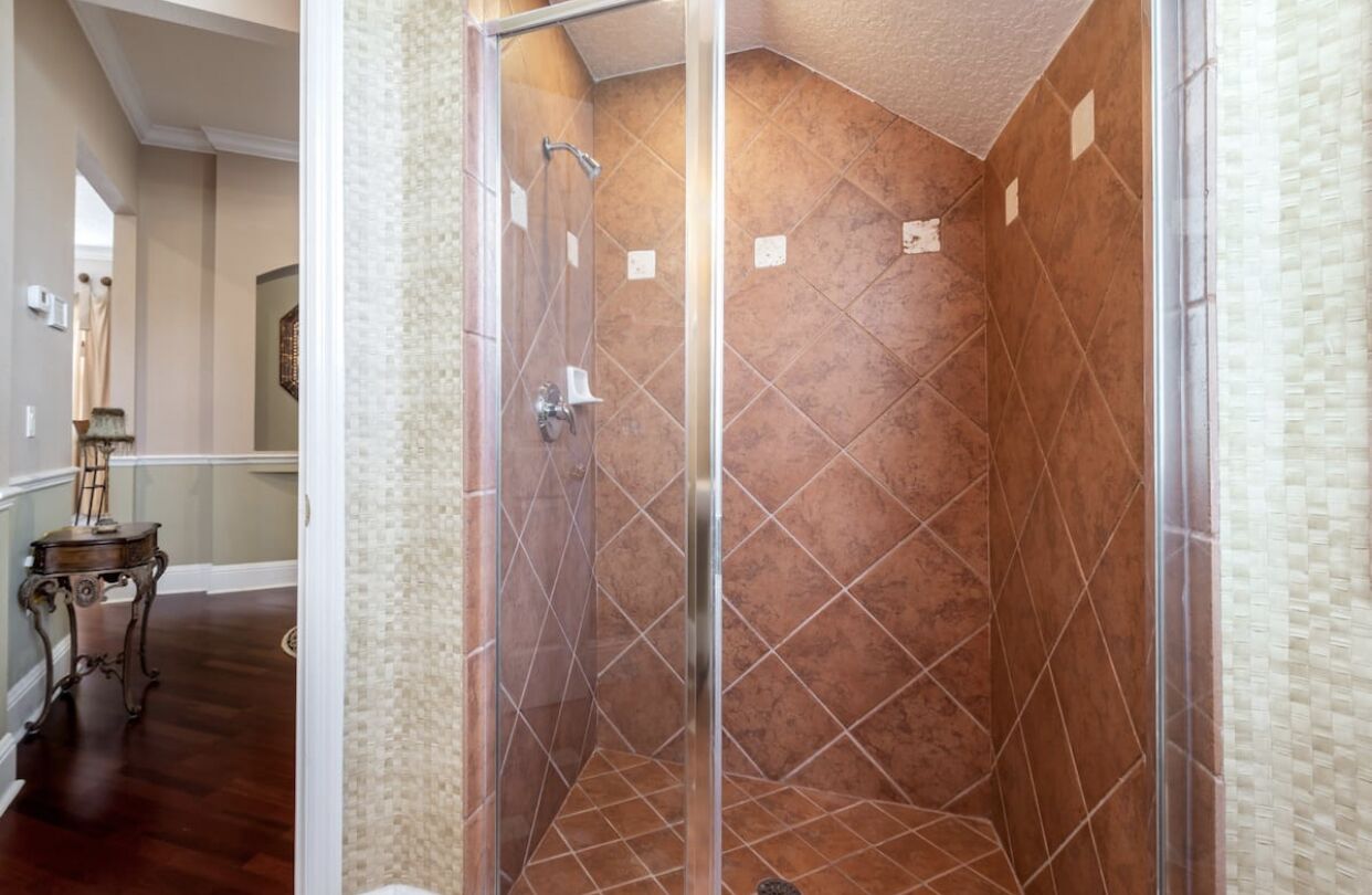 A glass-enclosed shower with a geometric tile pattern.
