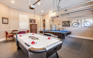 A room with a foosball table, pool table, and a billiards table. There are chairs and a table with a painting on the wall. - Disney theme 5 bed 5 bath with pool (Kissimmee)
