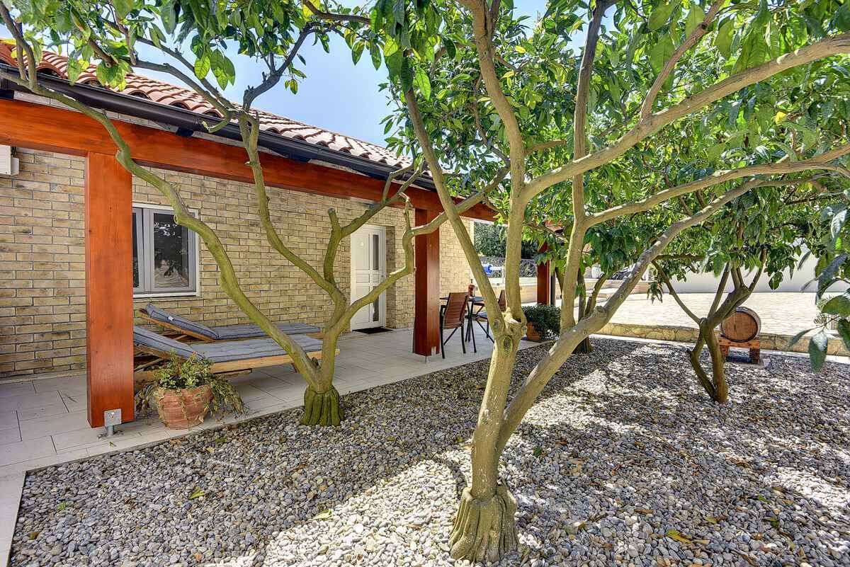 A house with a tiled roof, a brick exterior, and a gravel driveway.