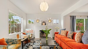 A living room with a sofa, coffee table, and a fireplace. - Newly Remodeled Charming and Contemporary Home (Santa Barbara)