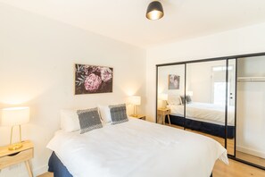 Relax in comfort with a large bed, bedside tables, and a spacious mirror.