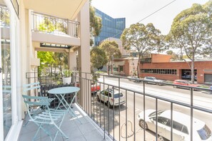 Enjoy a quiet moment on the balcony with a table and chairs overlooking the city.