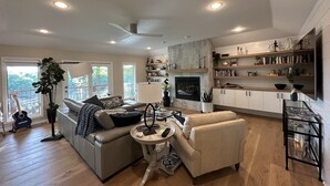 A spacious living room with a fireplace, a sofa, a coffee table, and a TV stand. - Beautiful and relaxing Golf & Lake retreat waiting just for you!!  (Hot Springs Village)