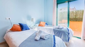 Een hotelkamer met twee bedden, een groot raam en uitzicht op buiten.