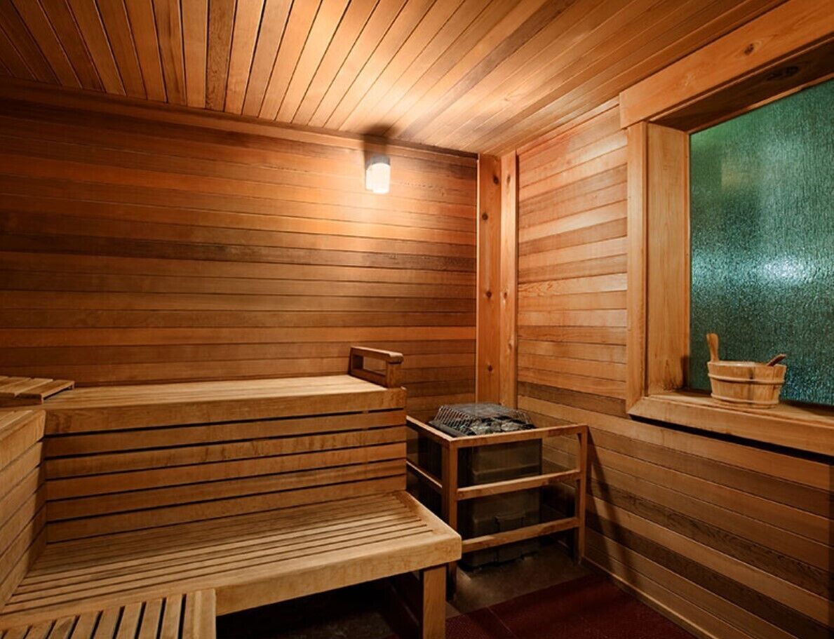 A wooden sauna with benches and a small table.