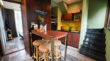 Une cuisine moderne avec un bar en bois, des tabourets en osier et une table à manger.
