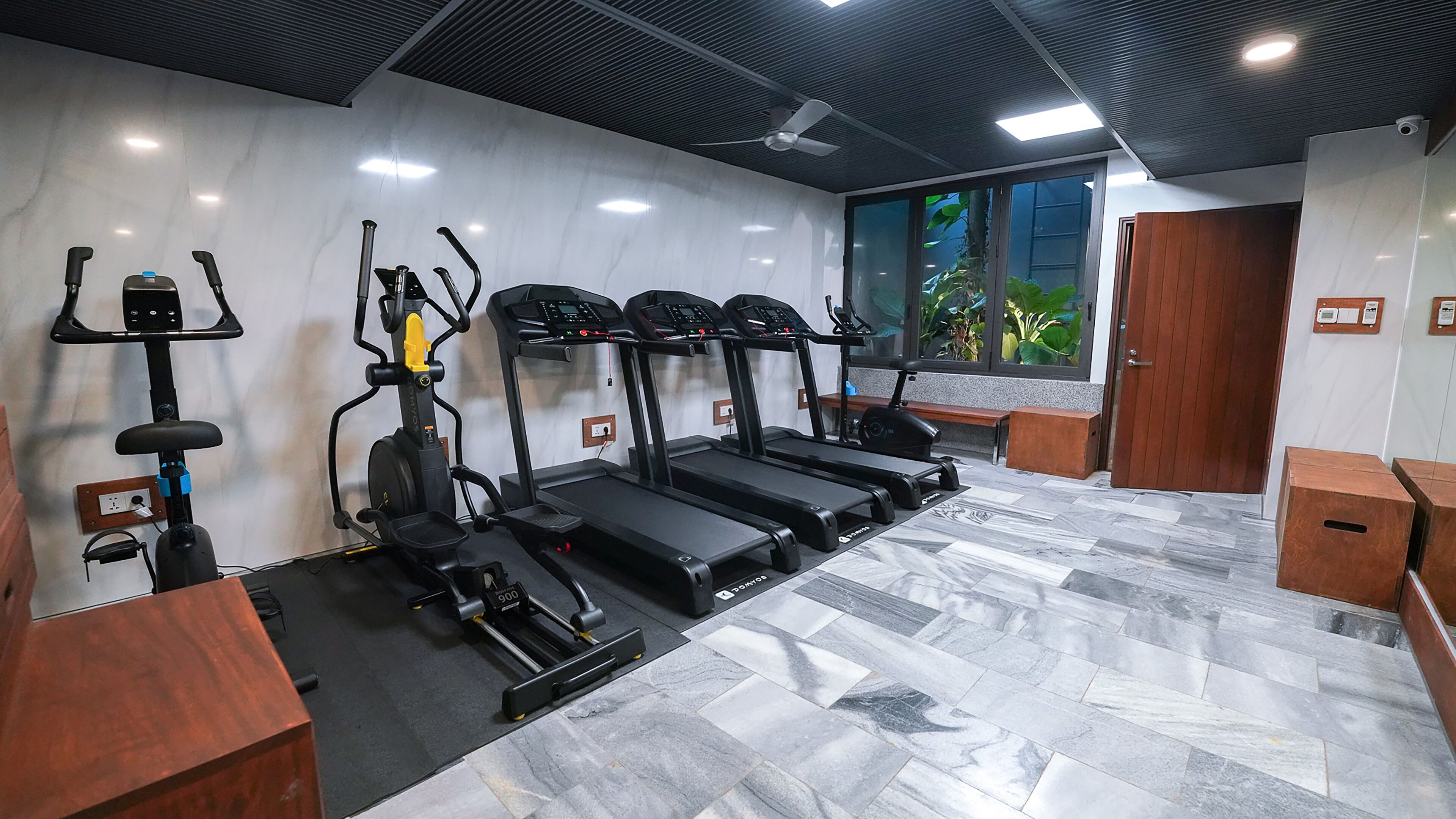 A gym with treadmills, a stationary bike, and a rowing machine.