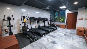 A gym with treadmills, a stationary bike, and a rowing machine.