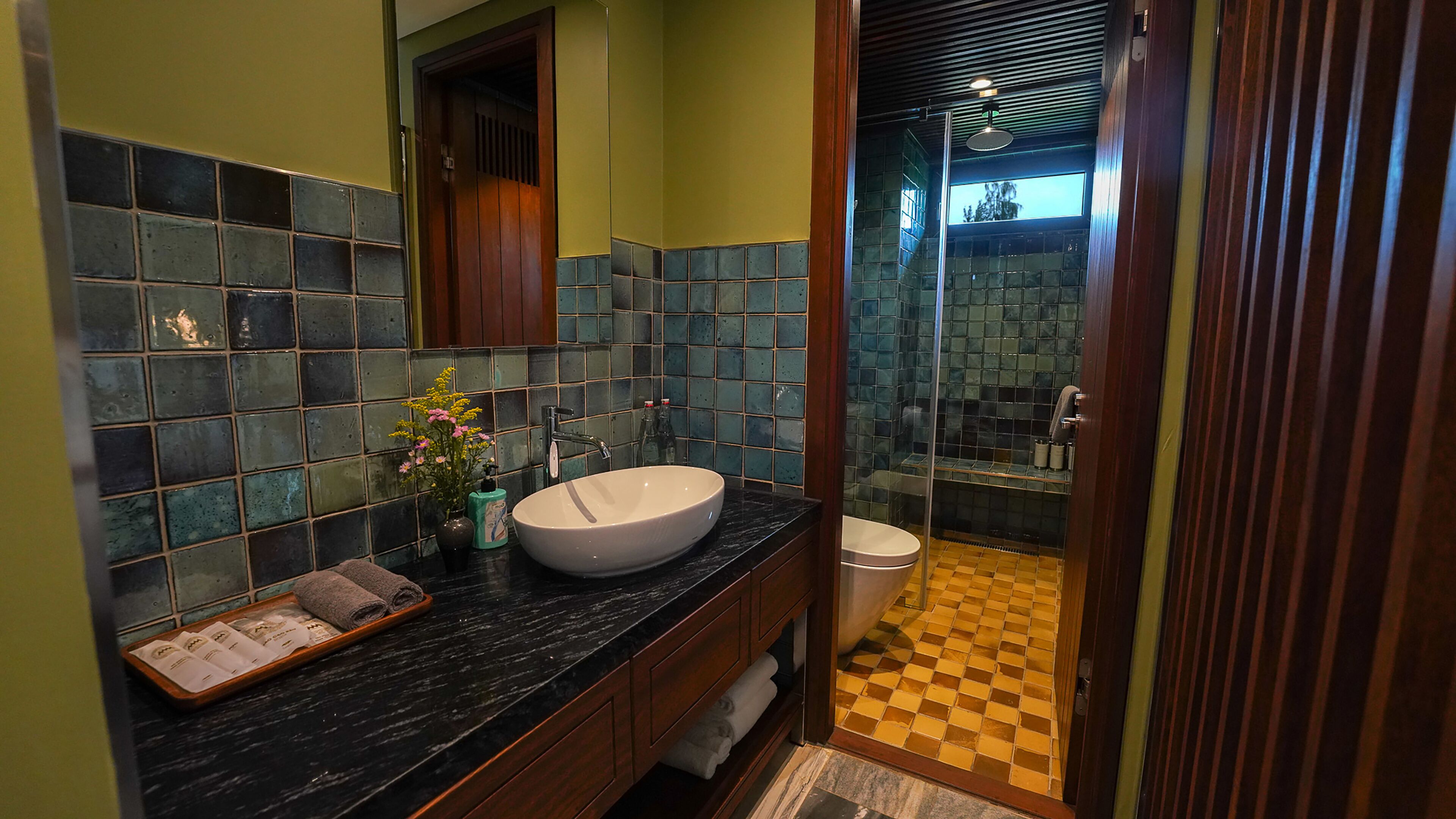 A bathroom with a large sink, mirror, and shower area.