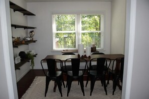 A dining area with a wooden table, black chairs, and white window blinds. - Beautiful Private Setting !!! (Bristol)